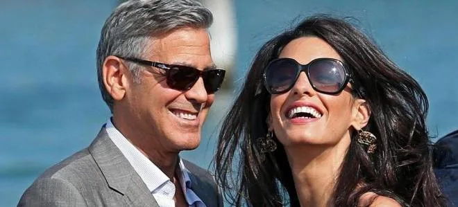 Ο George Clooney και η Amal Alamuddin χαμογελαστοί με γυαλιά ηλίου.