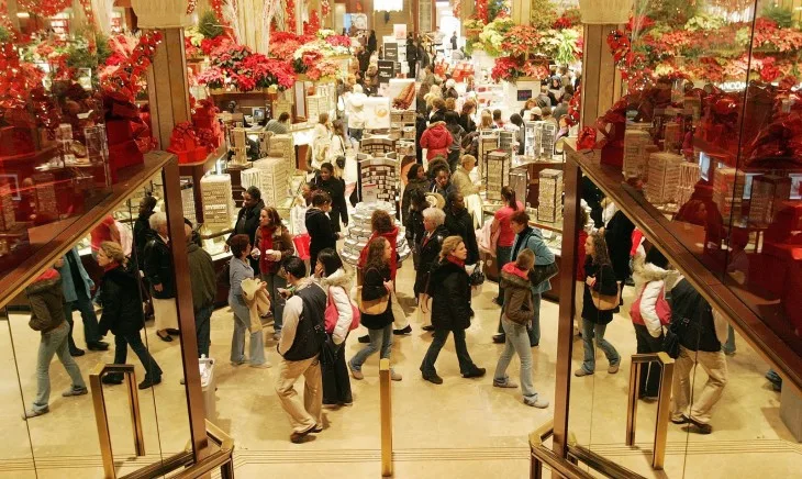 Πλήθος κόσμου σε πολυκατάστημα με χριστουγεννιάτικο στολισμό.