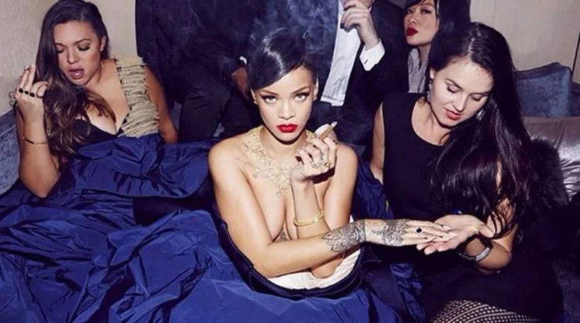 Η Rihanna με μπλε τουαλέτα Zac Posen κρατώντας πούρο
