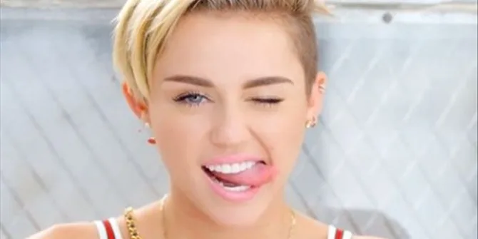 Η Miley Cyrus κλείνει το μάτι και βγάζει τη γλώσσα της.