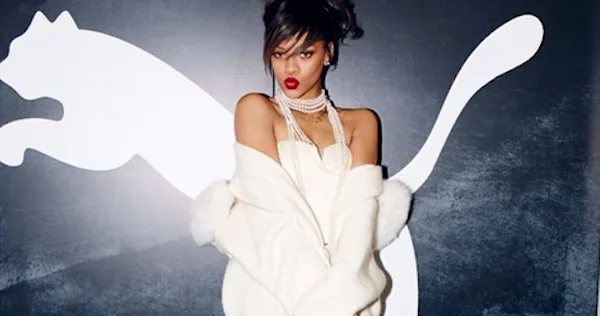 Η Rihanna ποζάρει μπροστά από το λογότυπο της Puma.