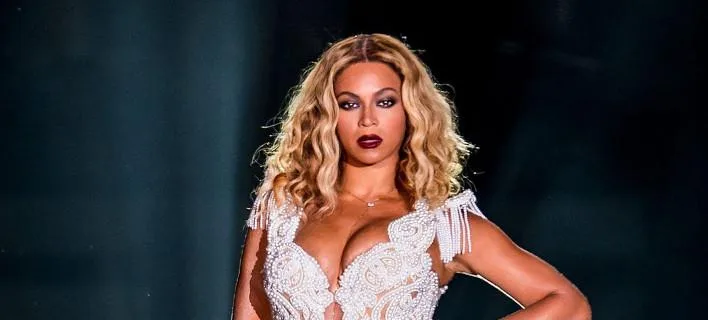 Η Beyonce με λευκό κορμάκι με πέρλες και κρόσσια στη σκηνή.