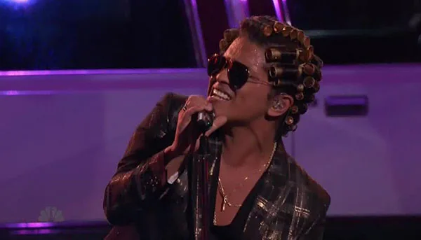Ο Bruno Mars στη σκηνή του The Voice με ρόλεϊ στα μαλλιά και γυαλιά ηλίου.