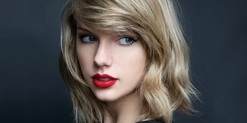 Κοντινό πορτρέτο της Taylor Swift με ξανθά μαλλιά και κόκκινο κραγιόν.