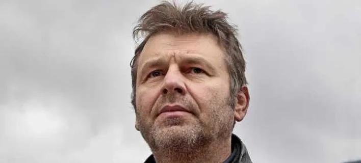 Κοντινό πλάνο του Απόστολου Γκλέτσου με φόντο τον ουρανό.