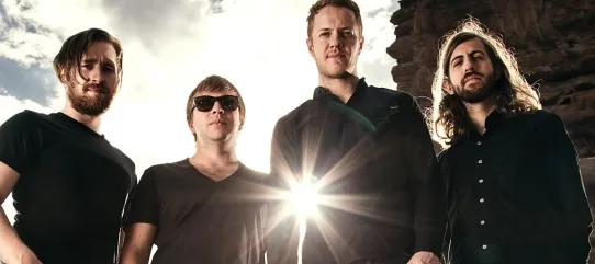 Το συγκρότημα Imagine Dragons ποζάρει μπροστά από έναν δυνατό ήλιο.