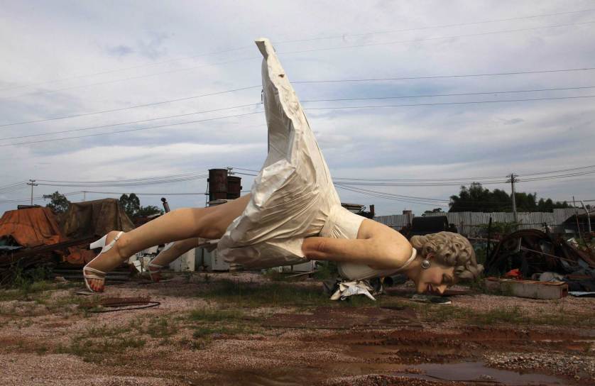 Giant statue of U.S. actress Marilyn Monroe is seen at the dump site of a garbage collecting company in Guigang