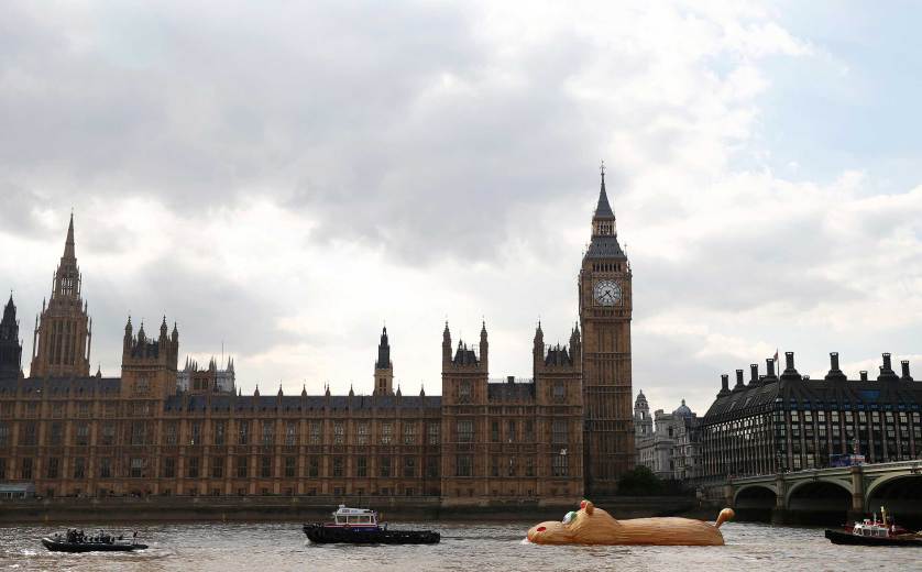 A sculpture of a giant hippopotamus built by artist Florentjin Hofman is towed up the Thames past the Houses of Parliament in central London