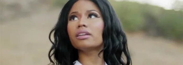 Η Nicki Minaj σε κοντινό πλάνο με μελαγχολικό ύφος σε εξωτερικό χώρο.
