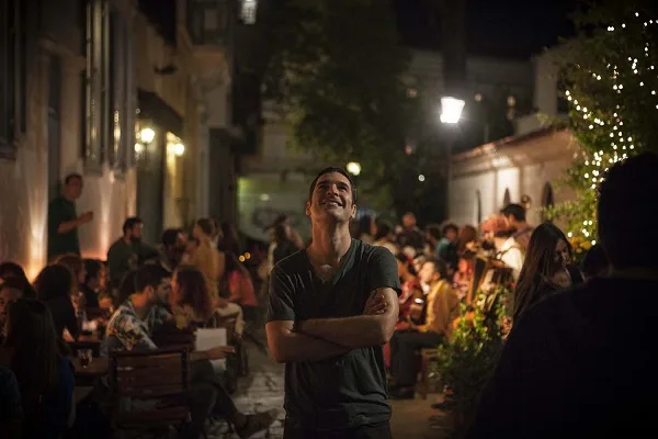 Ο Χριστόφορος Παπακαλιάτης σε νυχτερινό εξωτερικό χώρο με κόσμο.