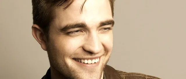 Ο Robert Pattinson χαμογελάει σε κοντινό πλάνο.