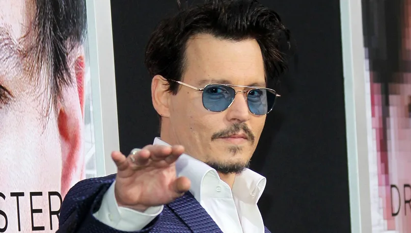 Johnny Depp με μπλε γυαλιά ηλίου και κοστούμι σε πρεμιέρα.