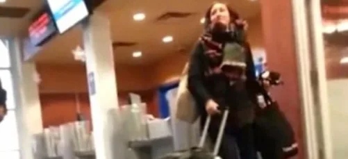 Γυναίκα σε σταθμό επιβατών με αποσκευές.