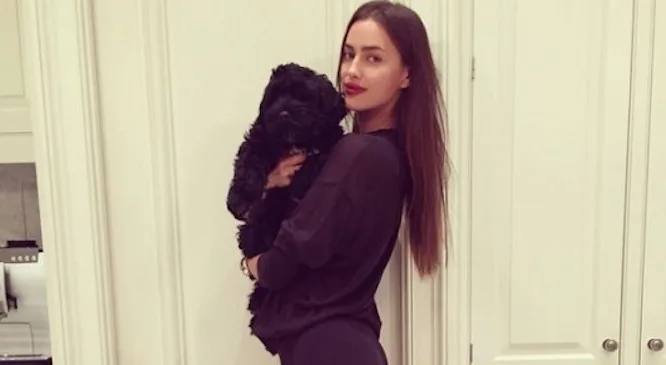 Η Irina Shayk κρατάει στην αγκαλιά της έναν μαύρο σκύλο.