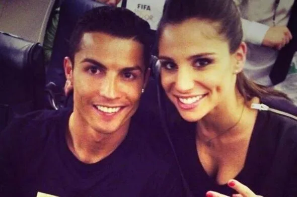 Ο Cristiano Ronaldo χαμογελά δίπλα σε μια μελαχρινή γυναίκα.
