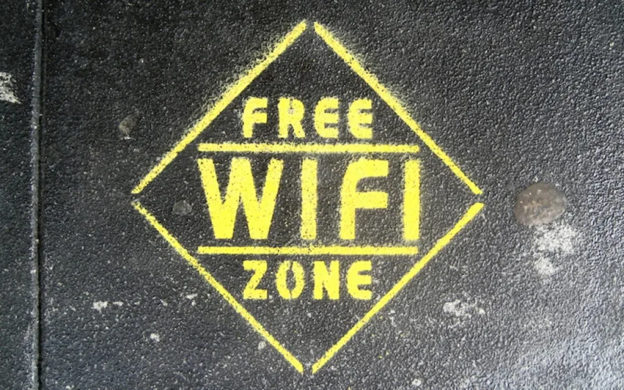 Κίτρινη σήμανση Free Wi-Fi Zone σε μαύρο οδόστρωμα.