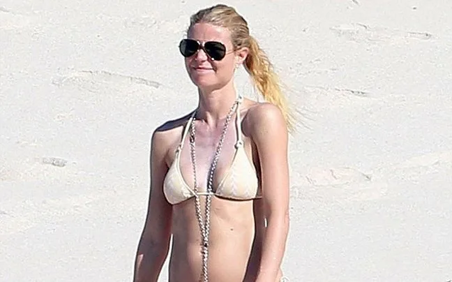 Η Gwyneth Paltrow με μαγιό και γυαλιά ηλίου σε παραλία.
