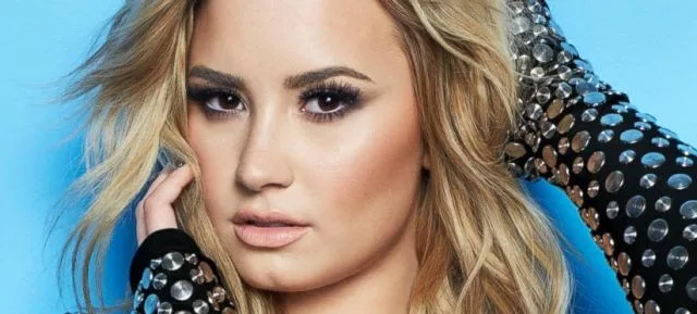 Η Demi Lovato σε κοντινό πλάνο με ξανθά μαλλιά και έντονο μακιγιάζ.