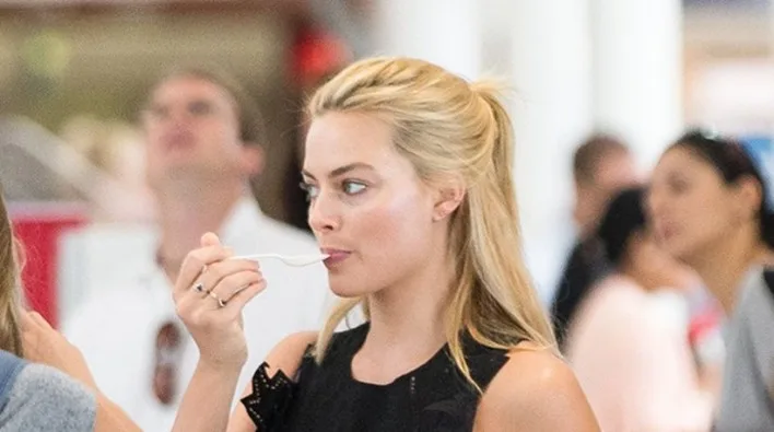 Η Margot Robbie τρώει με ένα πλαστικό κουτάλι.