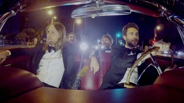 Ο Adam Levine και τα μέλη των Maroon 5 μέσα σε ένα κάμπριο αυτοκίνητο τη νύχτα.