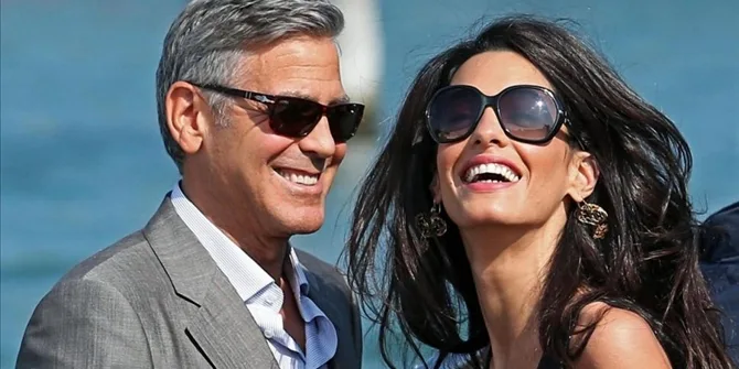 Ο George Clooney και η Amal Alamuddin χαμογελούν φορώντας γυαλιά ηλίου.