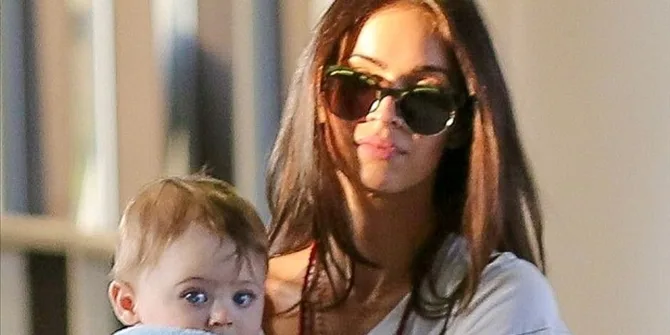 Η Megan Fox με γυαλιά ηλίου κρατάει στην αγκαλιά της το μωρό της.