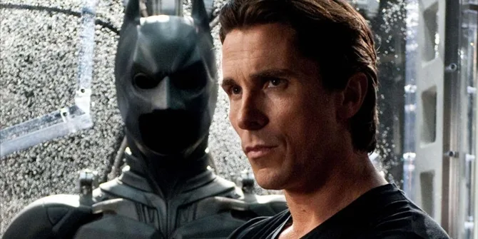 Ο Christian Bale ως Bruce Wayne δίπλα στη στολή του Batman.