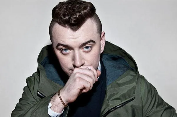 Ο Sam Smith με πράσινο τζάκετ και κοντό κούρεμα.