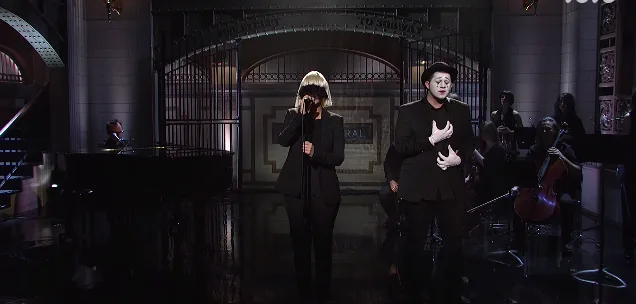 Η Sia στη σκηνή του Saturday Night Live με μίμο και ορχήστρα.