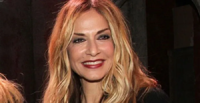 Κοντινό πλάνο της Άννας Βίσση με ξανθά μαλλιά και κόκκινο κραγιόν.