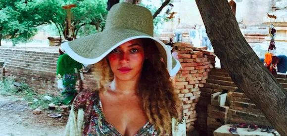 Η Beyonce με μεγάλο ψάθινο καπέλο σε εξωτερικό χώρο στην Ασία.