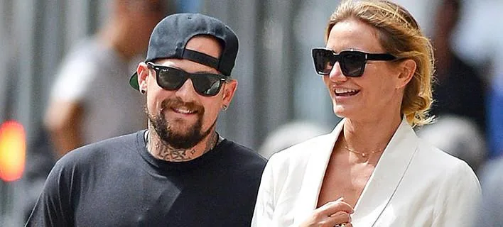 Η Cameron Diaz και ο Benji Madden περπατούν έξω φορώντας γυαλιά ηλίου.