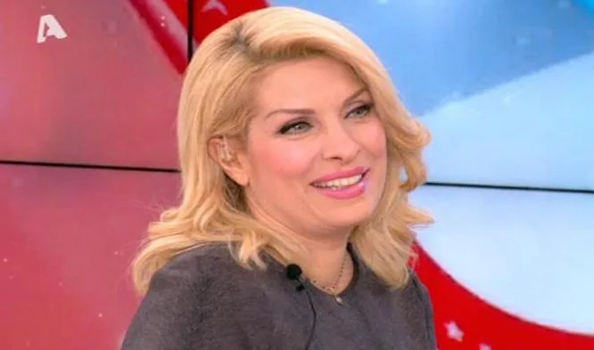 Η Ελένη Μενεγάκη χαμογελάει σε τηλεοπτικό πλατό.
