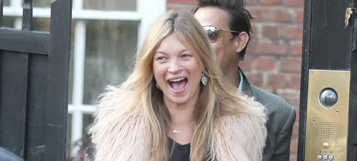 Η Kate Moss χαμογελάει φορώντας γούνινο παλτό δίπλα στον Jamie Hince.