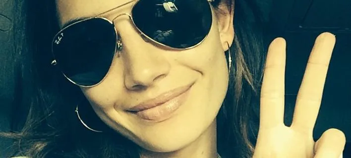 Η Lily Aldridge με γυαλιά ηλίου aviator κάνει το σήμα της ειρήνης.