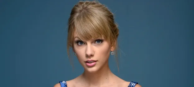 Η Taylor Swift σε κοντινό πλάνο με γαλάζιο φόντο