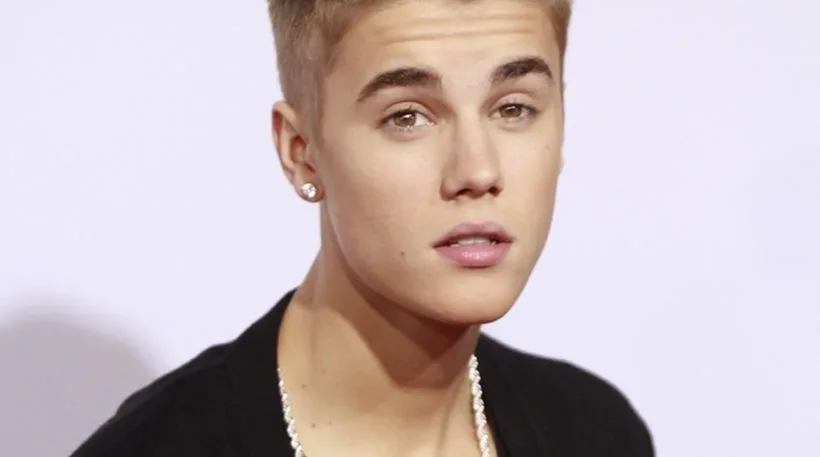 Ο Justin Bieber σε κοντινό πλάνο με ξανθά μαλλιά και σκουλαρίκι.