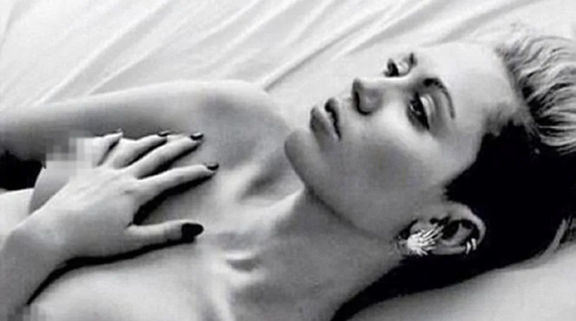 Η Miley Cyrus ξαπλωμένη σε ασπρόμαυρη φωτογραφία.