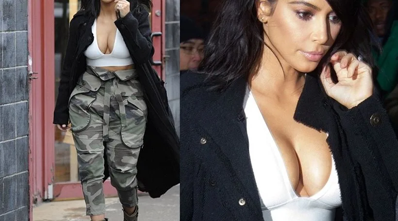 Η Kim Kardashian με λευκό crop top, παντελόνι παραλλαγής και μαύρο παλτό στη Νέα Υόρκη.
