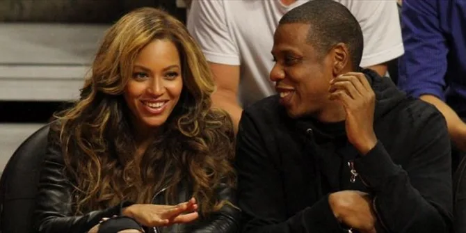 Η Beyonce και ο Jay Z χαμογελαστοί σε κερκίδες γηπέδου.