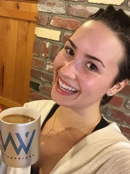 Η Demi Lovato χωρίς μακιγιάζ κρατώντας μια κούπα καφέ.