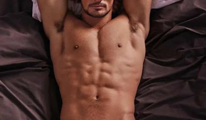 Ο David Gandy ξαπλωμένος σε κρεβάτι χωρίς μπλούζα