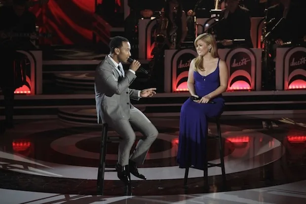 Ο John Legend και η Kelly Clarkson τραγουδούν σε σκηνή.