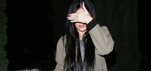 Η Kylie Jenner καλύπτει το πρόσωπό της με το χέρι της.