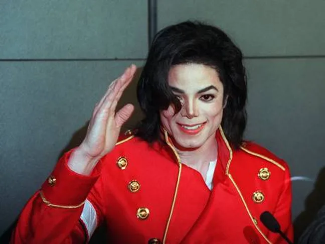 Ο Michael Jackson με κόκκινο στρατιωτικό σακάκι χαιρετάει.