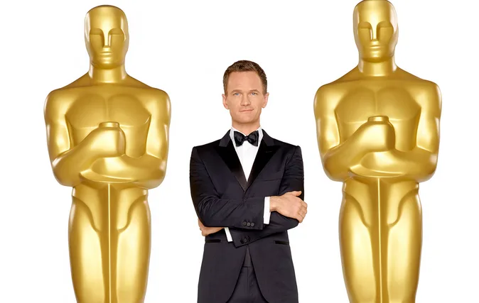 Ο Neil Patrick Harris ανάμεσα σε δύο αγάλματα των βραβείων Όσκαρ.