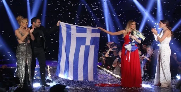 Η Μαρία Έλενα Κυριάκου στη σκηνή του Eurosong 2015 με την ελληνική σημαία.