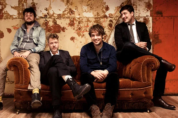 Το συγκρότημα Mumford and Sons σε έναν καναπέ.