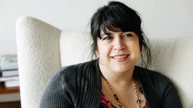 Η συγγραφέας E. L. James κάθεται σε μια λευκή πολυθρόνα.