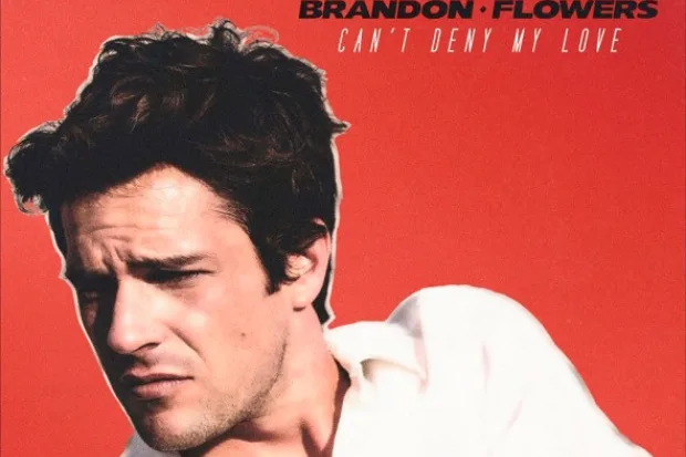 Ο Brandon Flowers σε κόκκινο φόντο για το single Can’t Deny My Love.